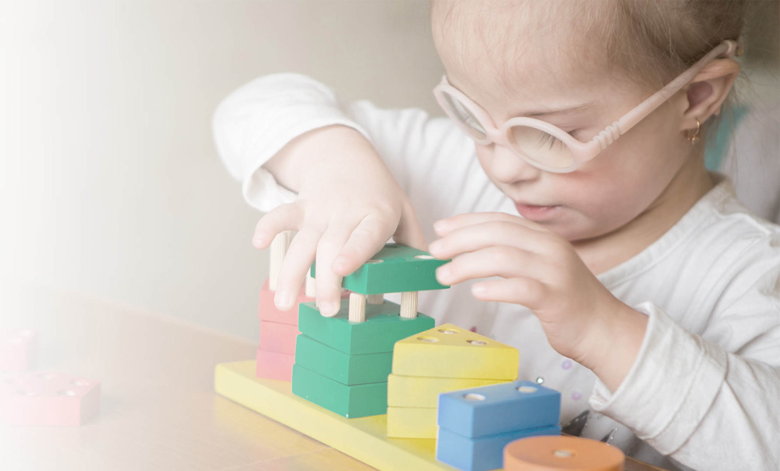 Picture of little girl working with pegs and blocks during her occupational therapy session.